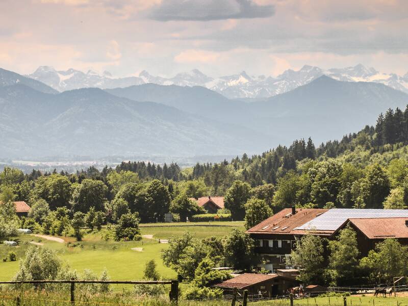 Blick von Dettenhausen Richtung Egling- ein Anwesen mit Wald und Bergpanorama im Hintergrund